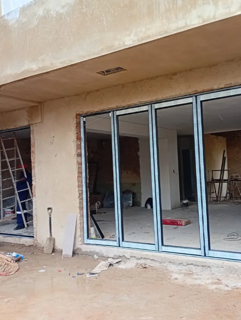 White aluminium sliding doors installed in a new-build shell