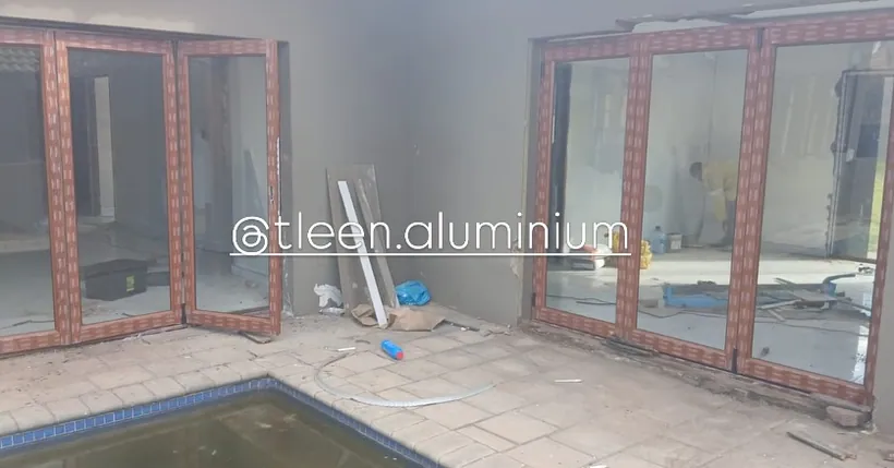 Wood-look aluminium folding doors newly fitted to a poolside elevation