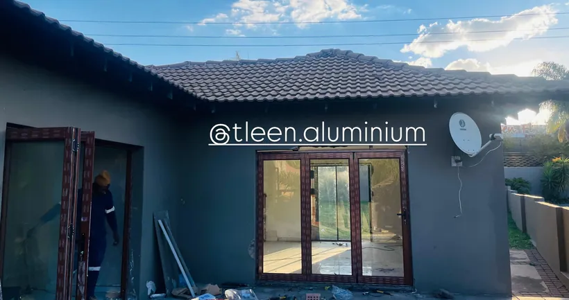 Charcoal aluminium double doors on a dark-painted house elevation