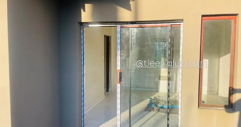 Interior aluminium slider dividing two rooms with clear glass