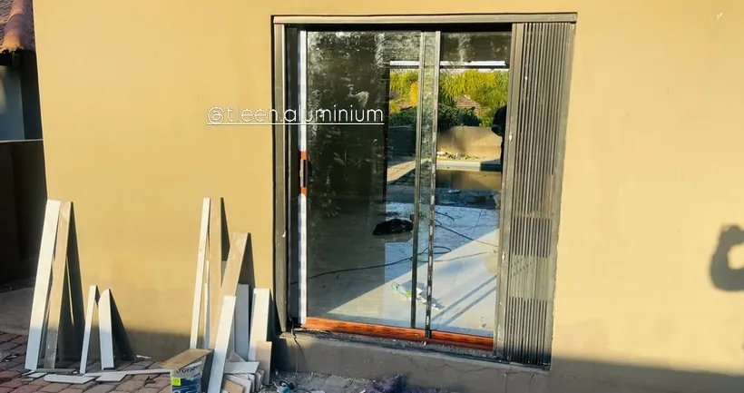 Aluminium sliding door fitted with a matching trellis security gate