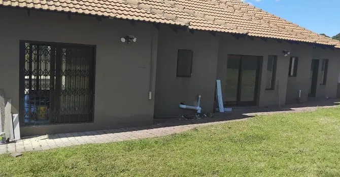 Grey house elevation with charcoal aluminium windows and trellis guards