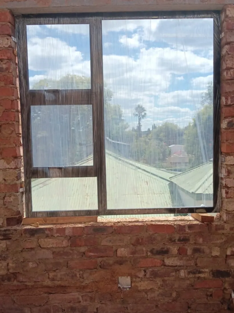 Charcoal top-hung window newly cut into an existing face-brick wall